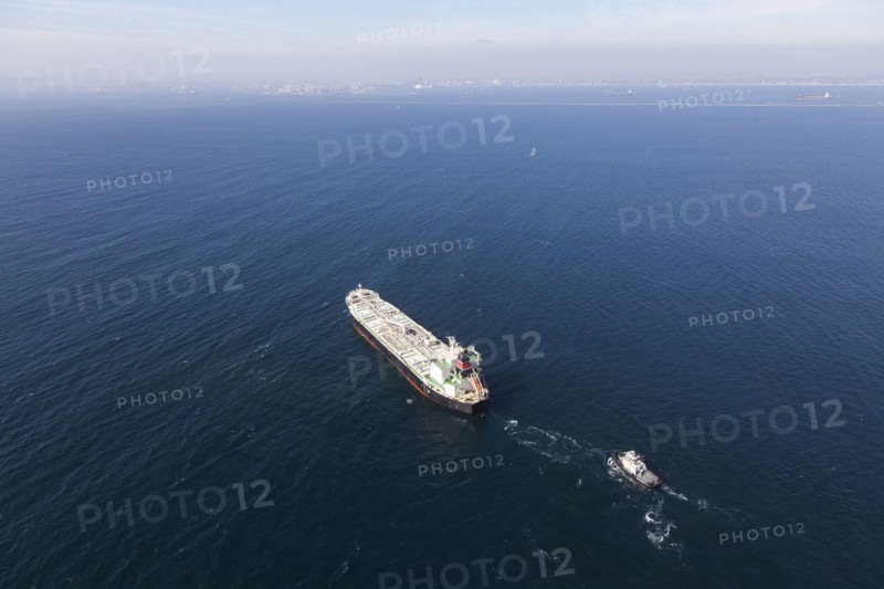 Oil tanker with tugboat at sea