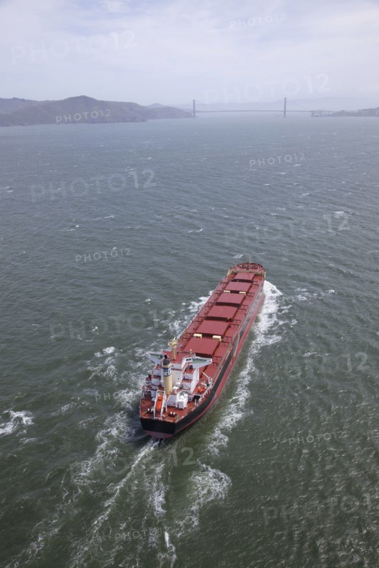 Aerial view of container ship in urban harbor