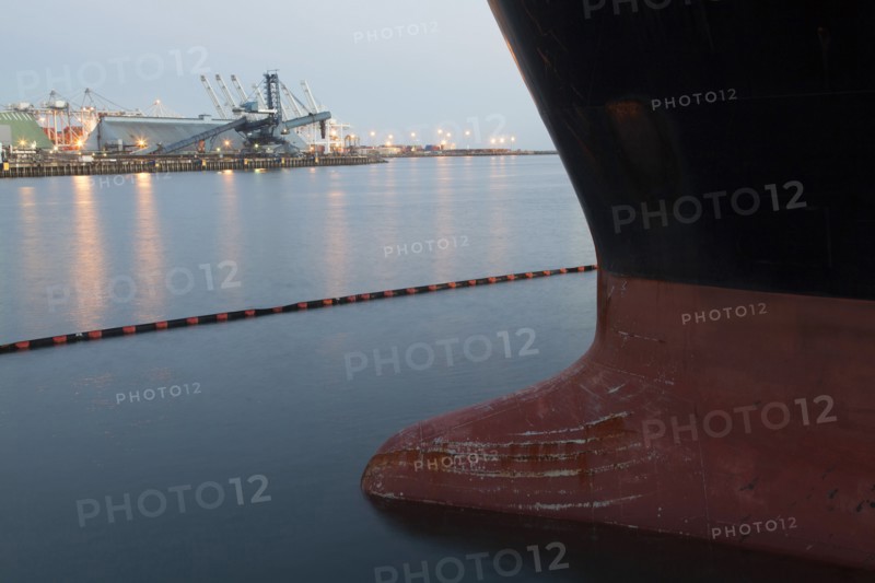 Close up of bow of ship docked in industrial harbor