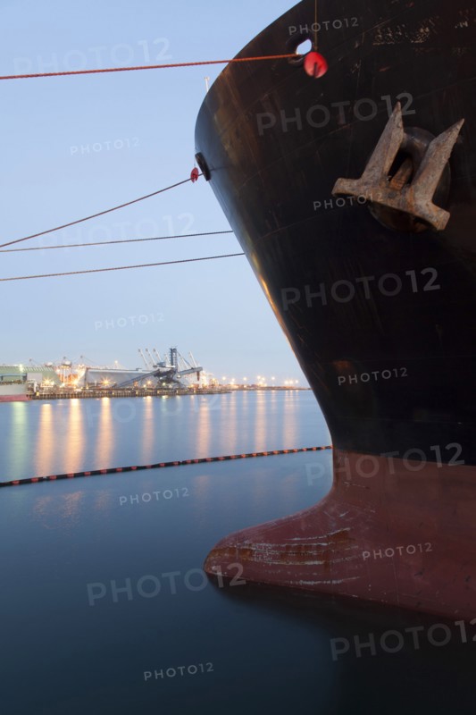 Close up of bow of ship docked in industrial harbor