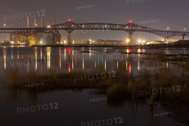 Reflection of illuminated bridge in still lake