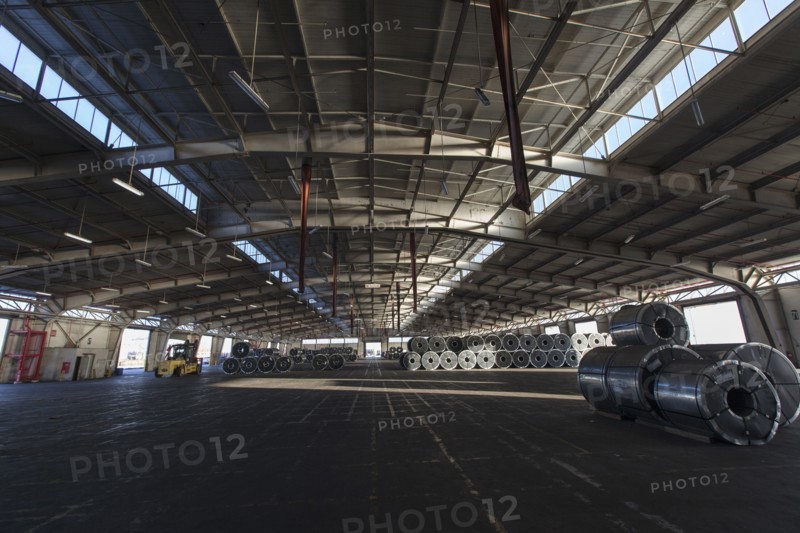 Metal rolls and forklift in warehouse
