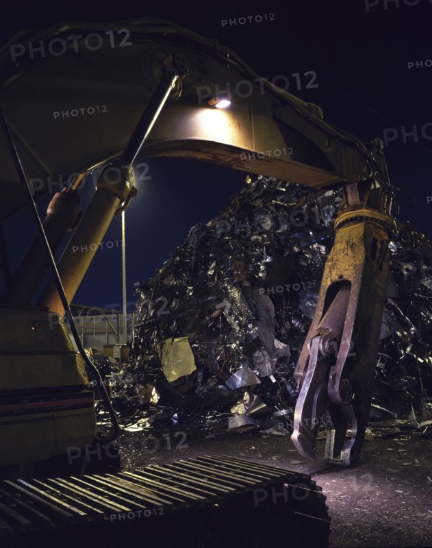 Mechanical grabber in junkyard at night