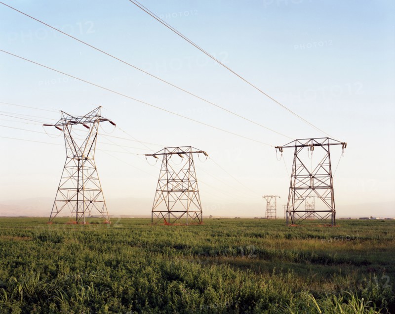 Electricity pylons in grass landscape