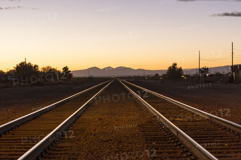 Railroad tracks in mountain landscape at sunset