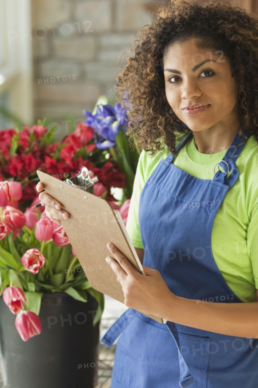 Mixed race florist holding clipboard