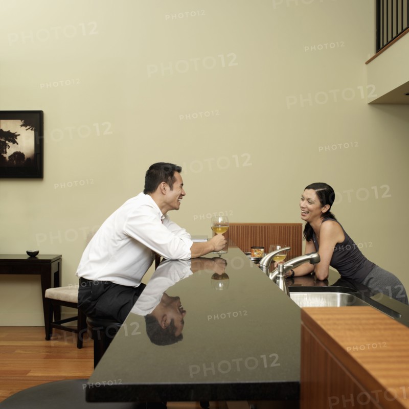 Asian couple talking in kitchen