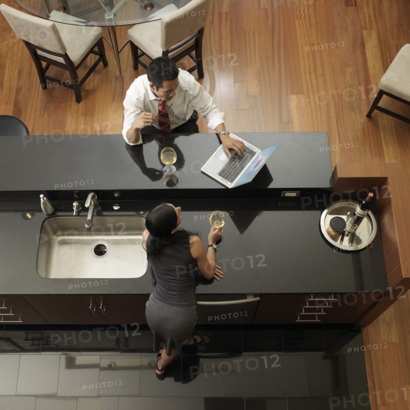 Asian couple looking at laptop in kitchen