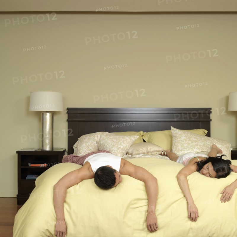 Asian couple laying on bed
