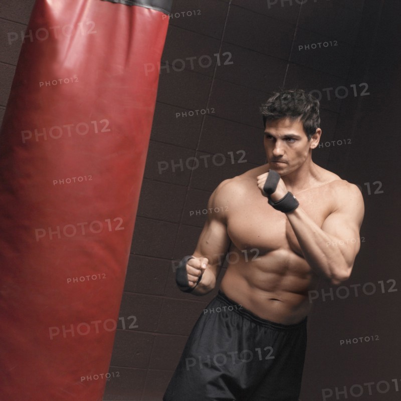 Caucasian man using punching bag