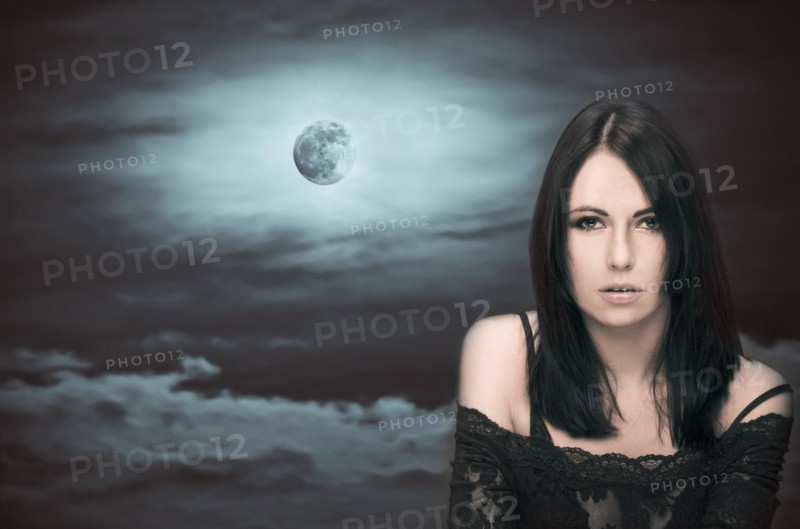 Caucasian woman in front of full moon