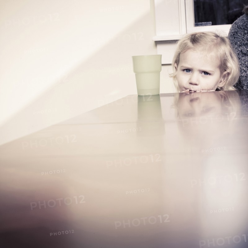 Caucasian girl peering over table