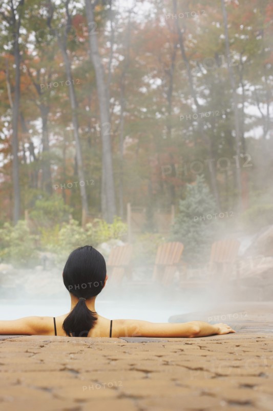 Rear view of woman sitting in hot tub