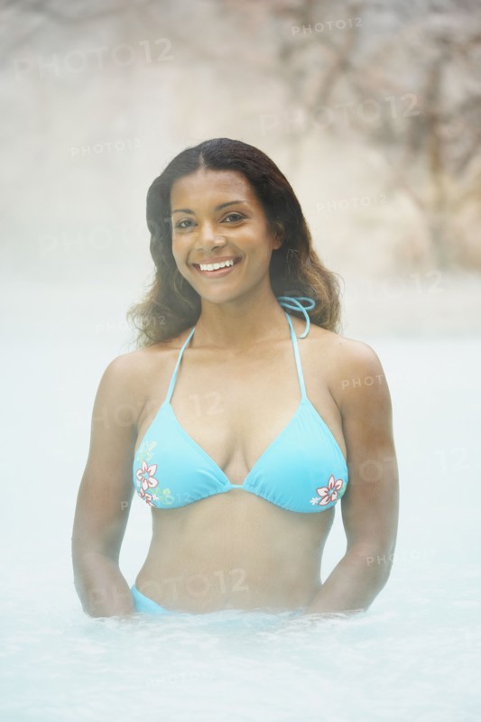 African woman standing in hot tub