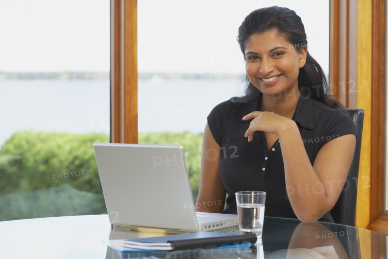 Indian woman at table with laptop