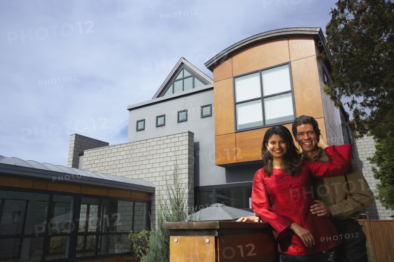 Couple hugging in front of modern house