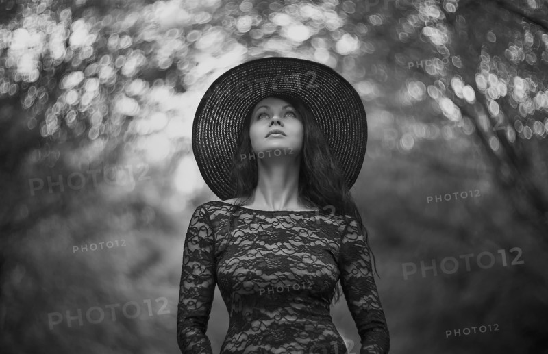 Caucasian woman wearing sun hat under trees