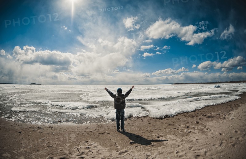 Caucasian boy cheering on ocean beach