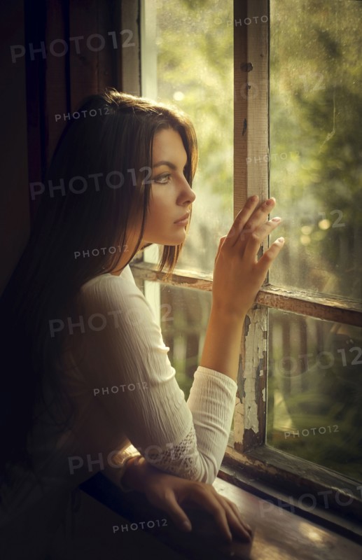 Caucasian woman daydreaming at window