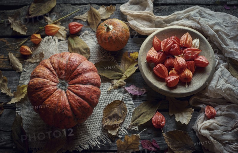 Pumpkins and autumn leaves on wooden table