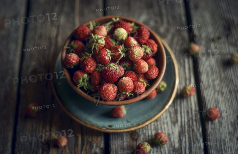Bowl of red strawberries on wooden table