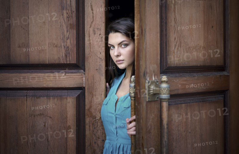 Caucasian woman opening wooden door