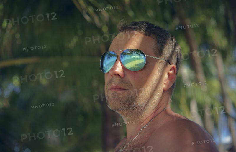 Serious man wearing sunglasses in summer