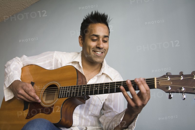 Mixed race man playing guitar