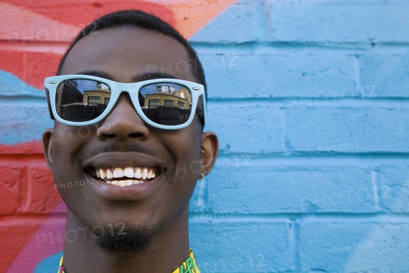 Close up of Black man wearing colorful sunglasses