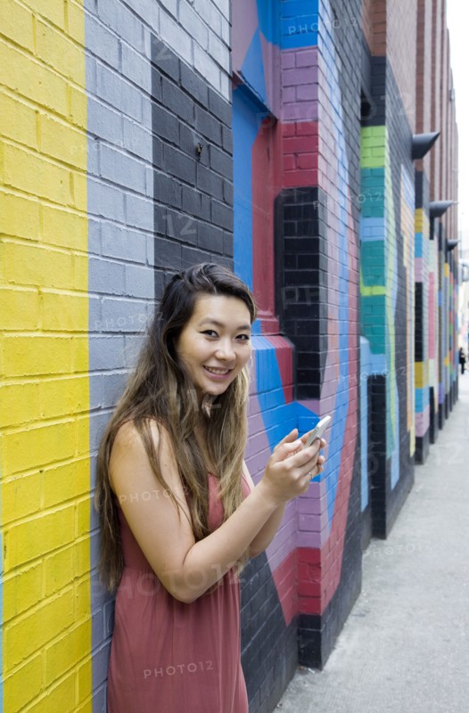Asian woman using cell phone outdoors