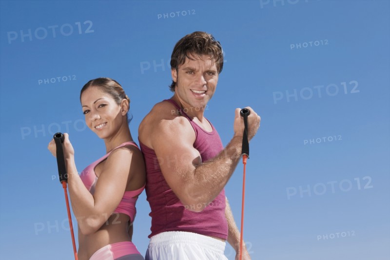 Hispanic couple exercising with exercise bands