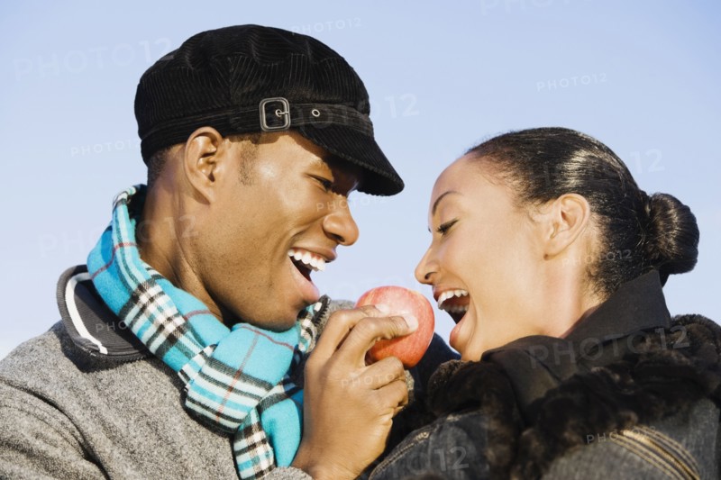 Multi-ethnic couple eating apple