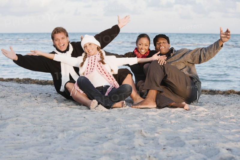 Multi-ethnic couples sitting on beach