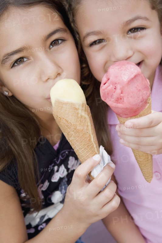Hispanic sisters eating ice cream cones