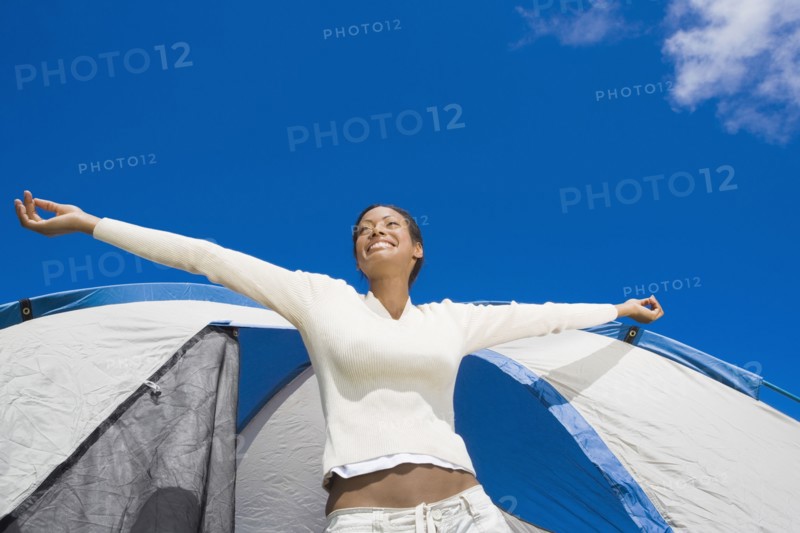 Hispanic woman stretching in front of tent