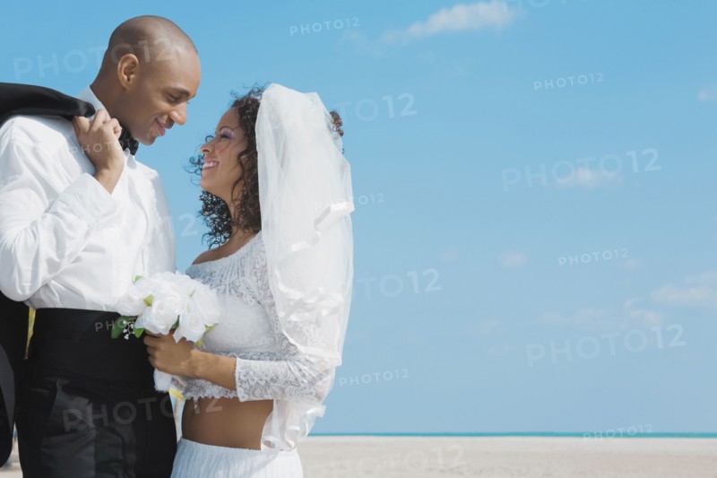 Multi-ethnic bride and groom smiling at each other