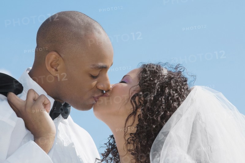 Multi-ethnic bride and groom kissing