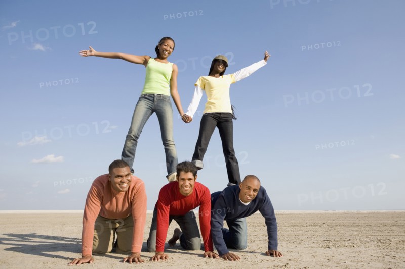 Multi-ethnic friends making human pyramid