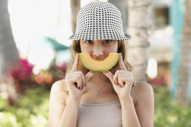 Hispanic woman holding melon slice