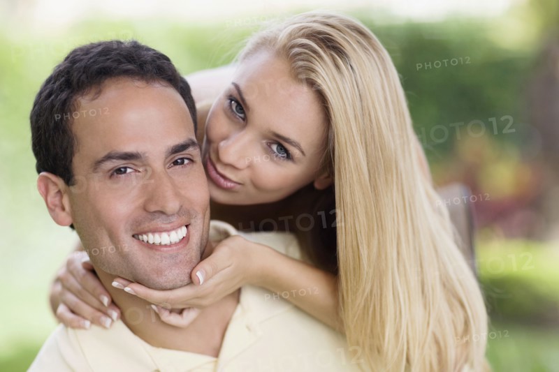Hispanic woman kissing boyfriend's cheek