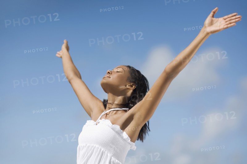 Hispanic woman with arms raised
