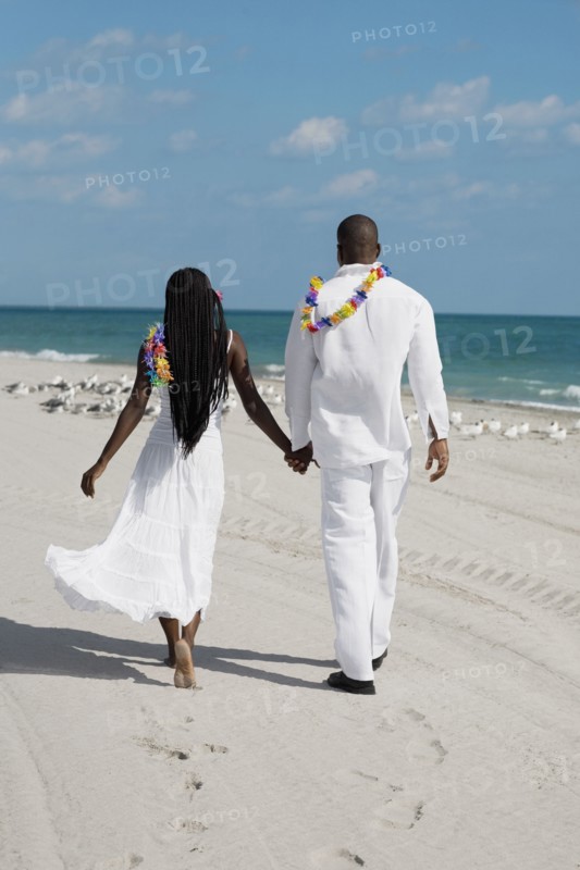African couple holding hands at beach