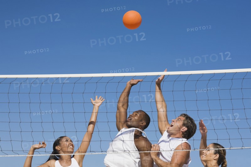 Multi-ethnic friends playing volleyball