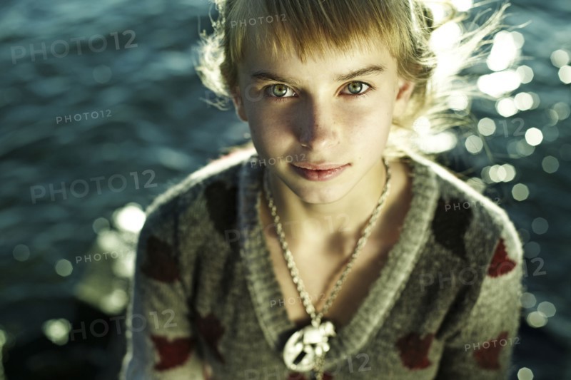 Caucasian girl sitting by water