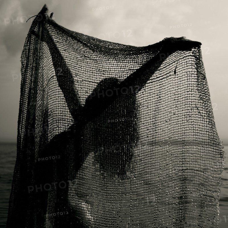 Caucasian girl playing with net on beach