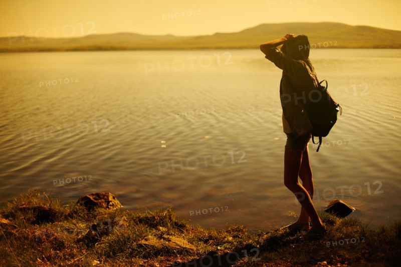 Caucasian woman standing by still rural lake