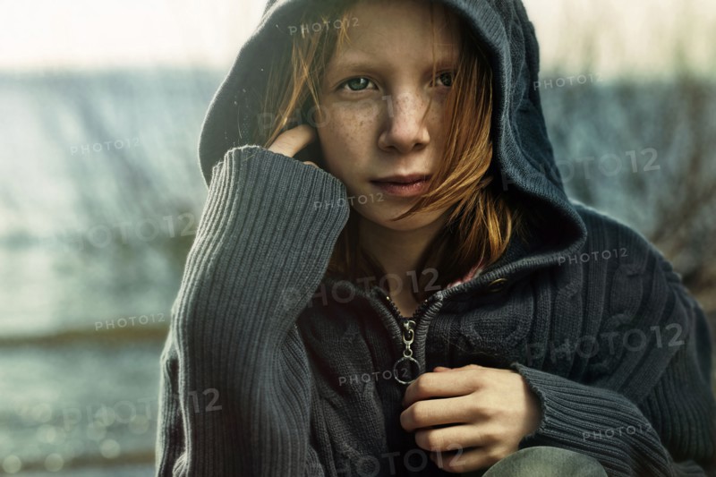 Caucasian girl wearing hooded sweater on beach