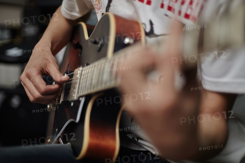Close up of Caucasian man playing guitar
