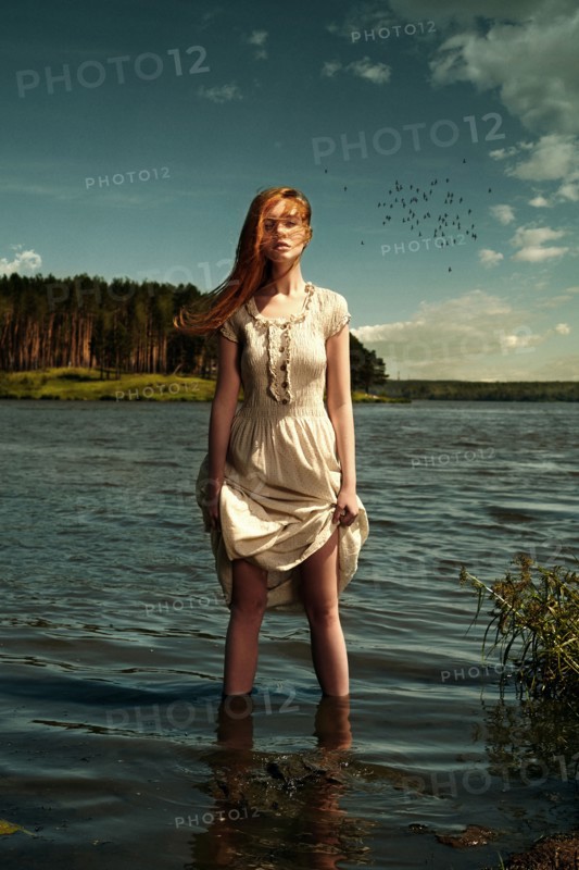 Caucasian woman standing in remote lake