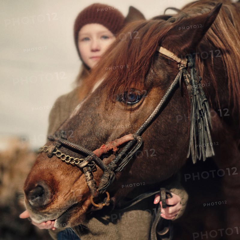 Caucasian girl holding rein of horse